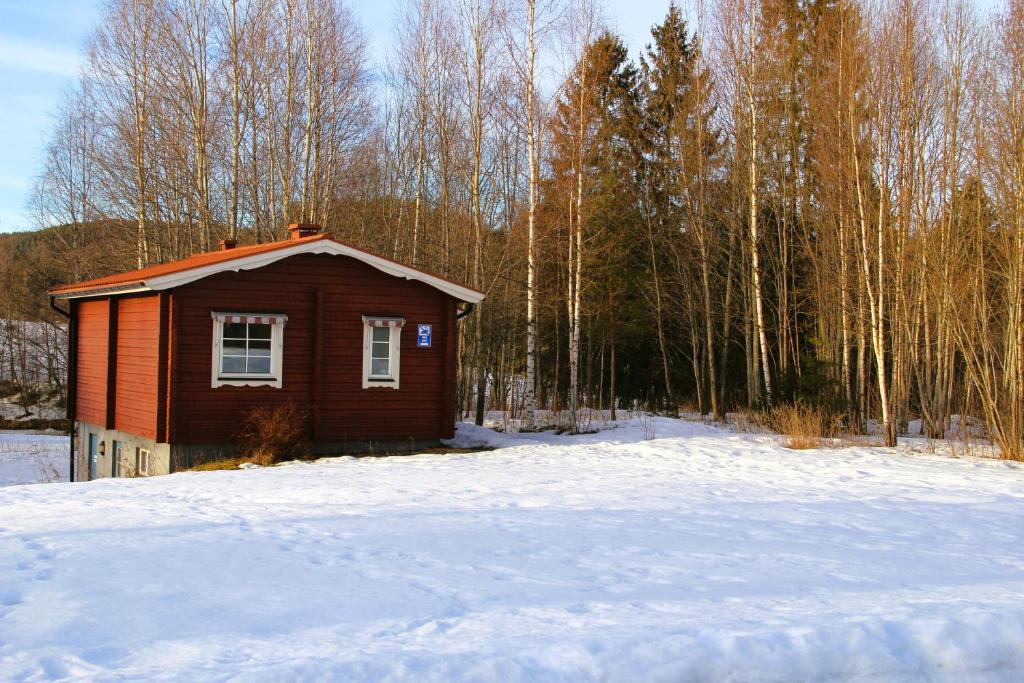 a small cabin in the snow in a forest at Fristad Nature House in Torsby