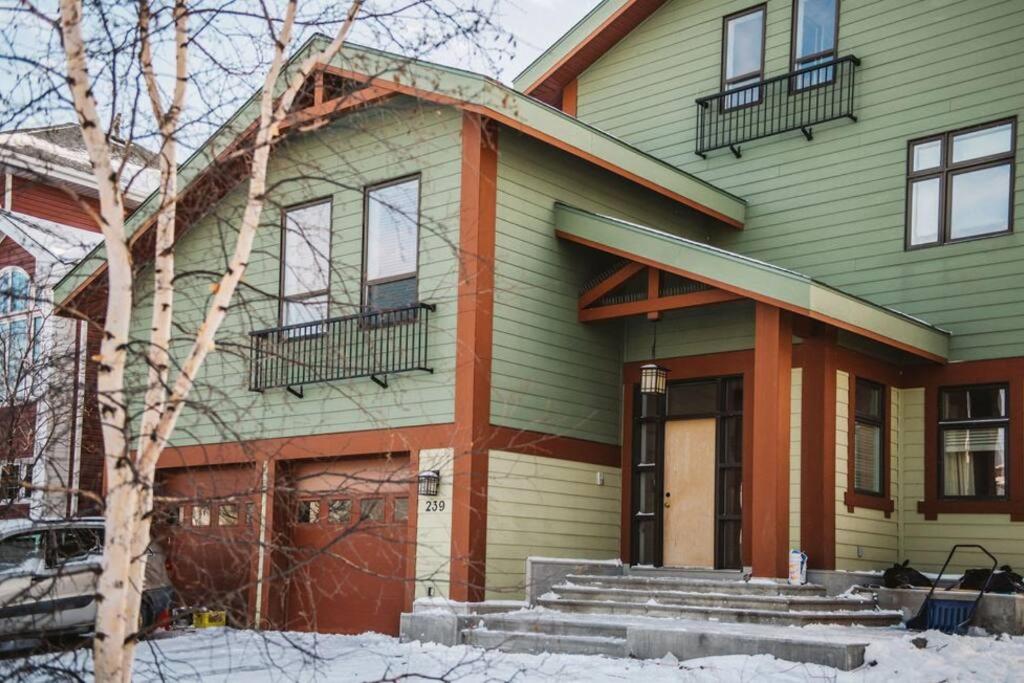 a green and orange house with snow in front of it at The Niven Lake Retreat in Yellowknife