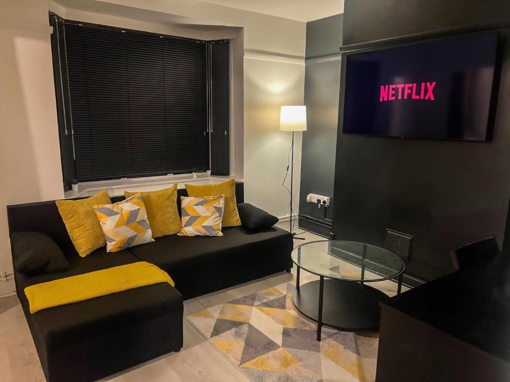 a living room with a couch and a tv at Sleek Cosy Flat Camden in London