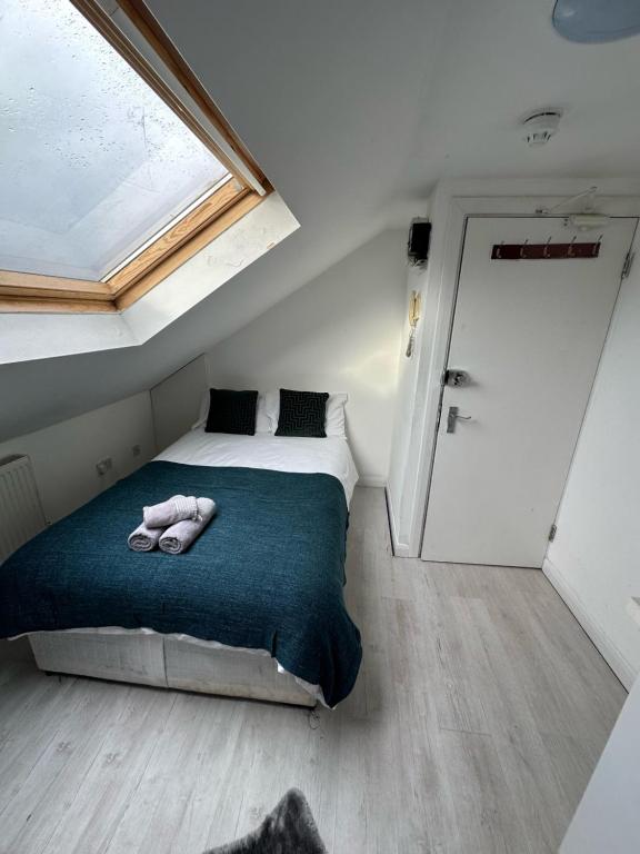 a bedroom with a bed with two towels on it at Cozy Urban Terraced Studio in London