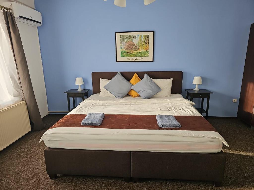 a bedroom with a large bed with two tables at Joy Guesthouse in Siófok