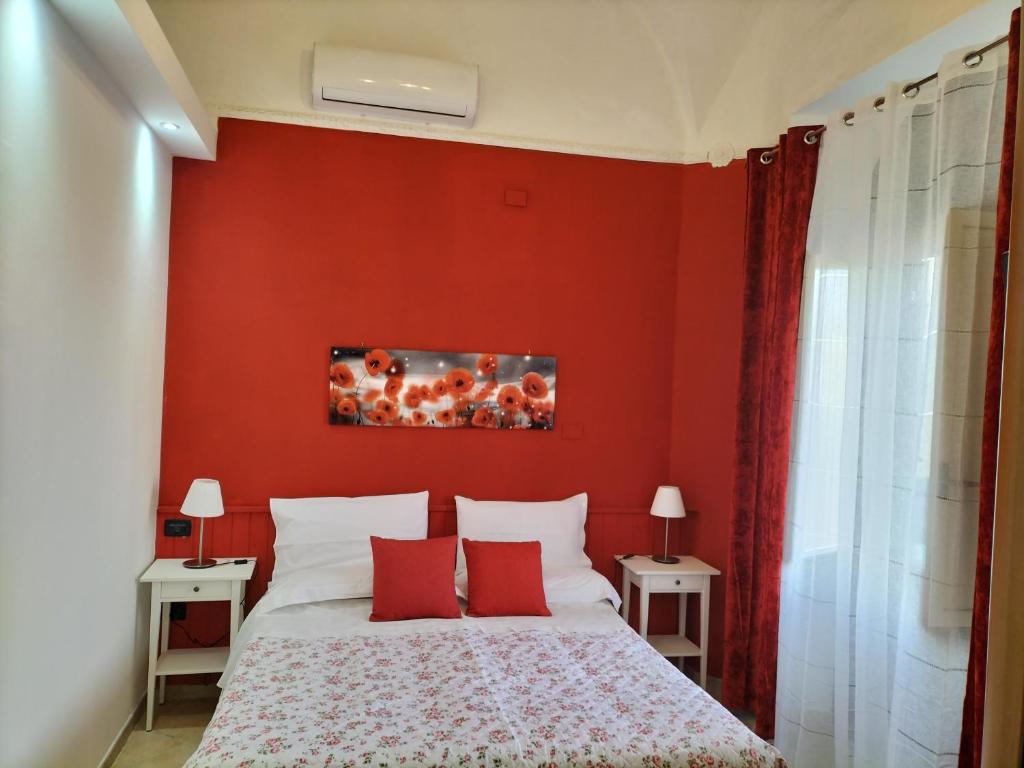 a bedroom with red walls and a bed with red pillows at B&B Da Rosa in Linguaglossa