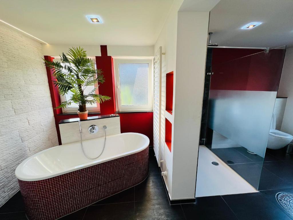 a bathroom with a large tub and a shower at Beautiful Apartment I 19 Beds I Parking I Fast WiFi in Gütersloh