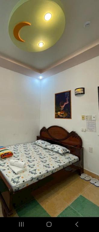 - une chambre avec un lit et un plafond jaune dans l'établissement Nhà nghỉ Bình Minh, à Ấp Rạch Mẹo
