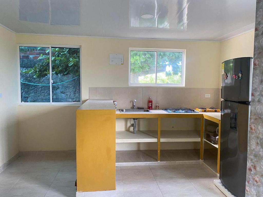 eine Küche mit einer gelben Theke und einem Kühlschrank in der Unterkunft Casa Nativa DUDA´S in Franshua