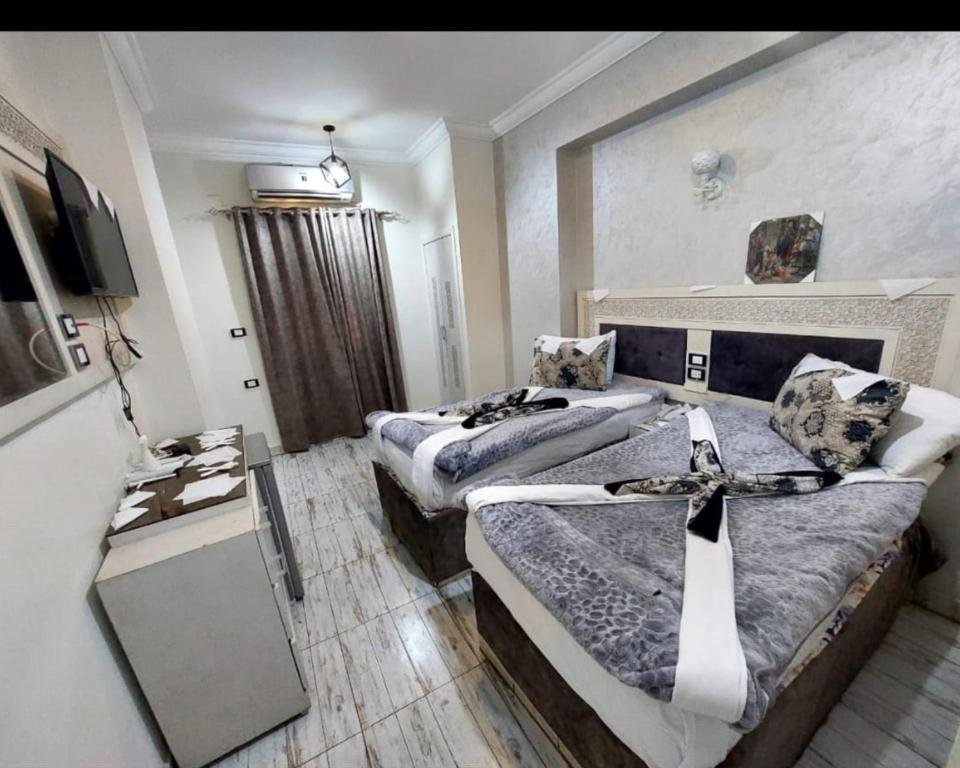 Habitación de hotel con 2 camas y TV en Al Amir Palace Hotel en Sūhāj