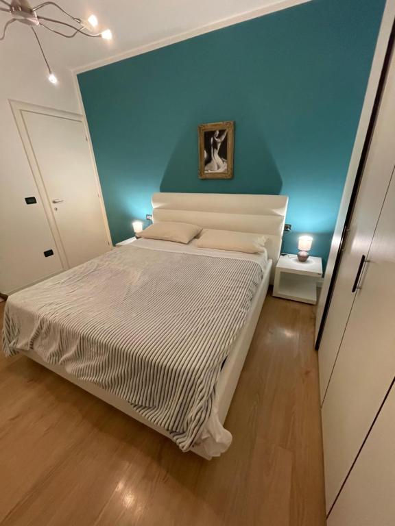 sypialnia z białym łóżkiem i niebieską ścianą w obiekcie Garden Love Venice w Mestre