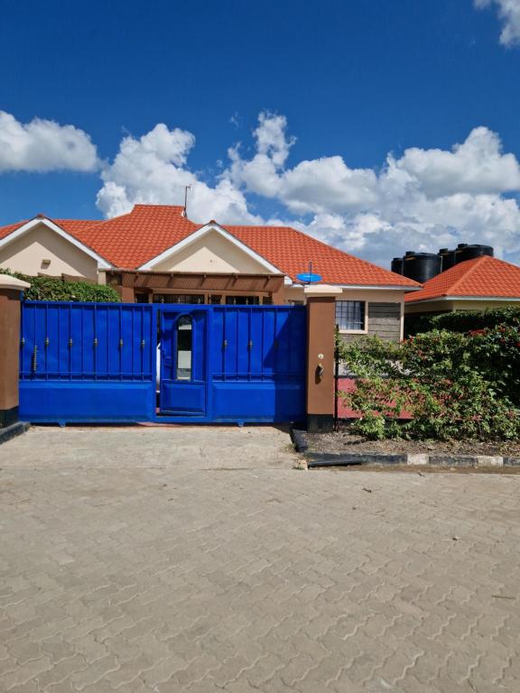 a blue fence in front of a house at Savanna Greens Joska in Nguluni