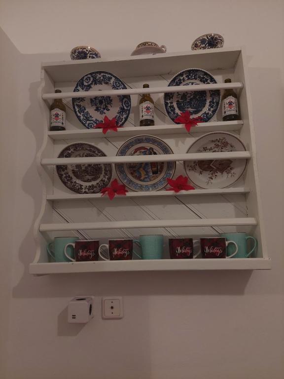 a shelf filled with plates and cups on a wall at Mesa Vrisi in Karpathos Town