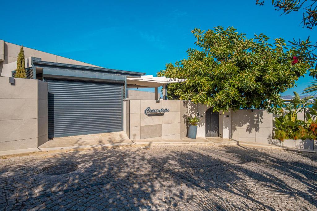 una casa con un garaje con un árbol delante en Çimentepe Residence Deluxe, en Bodrum City