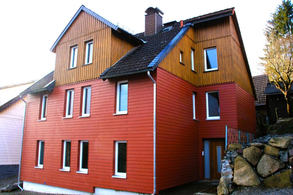 uma casa vermelha com um telhado preto em Harzhaus Drei Hexen em Tanne