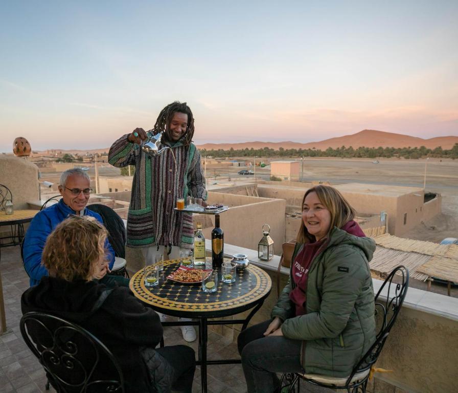 a group of people sitting around a table on a roof at Dar Duna in Adrouine