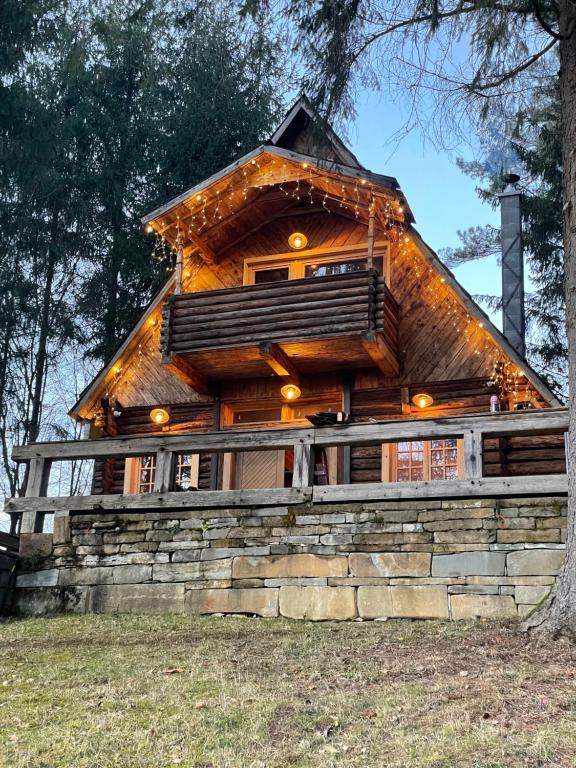 a log cabin on a hill with a tree at Cabana Craita in Vişeu de Sus