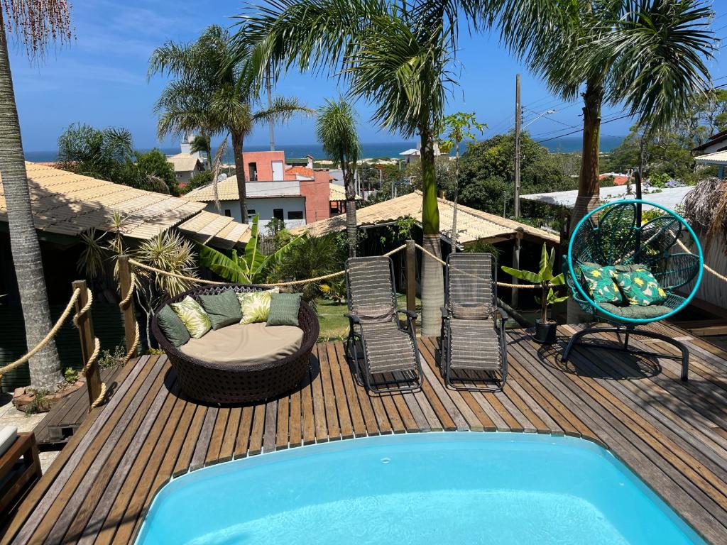 una terraza con piscina, sillas y un columpio en Pousada Mirante, en Florianópolis