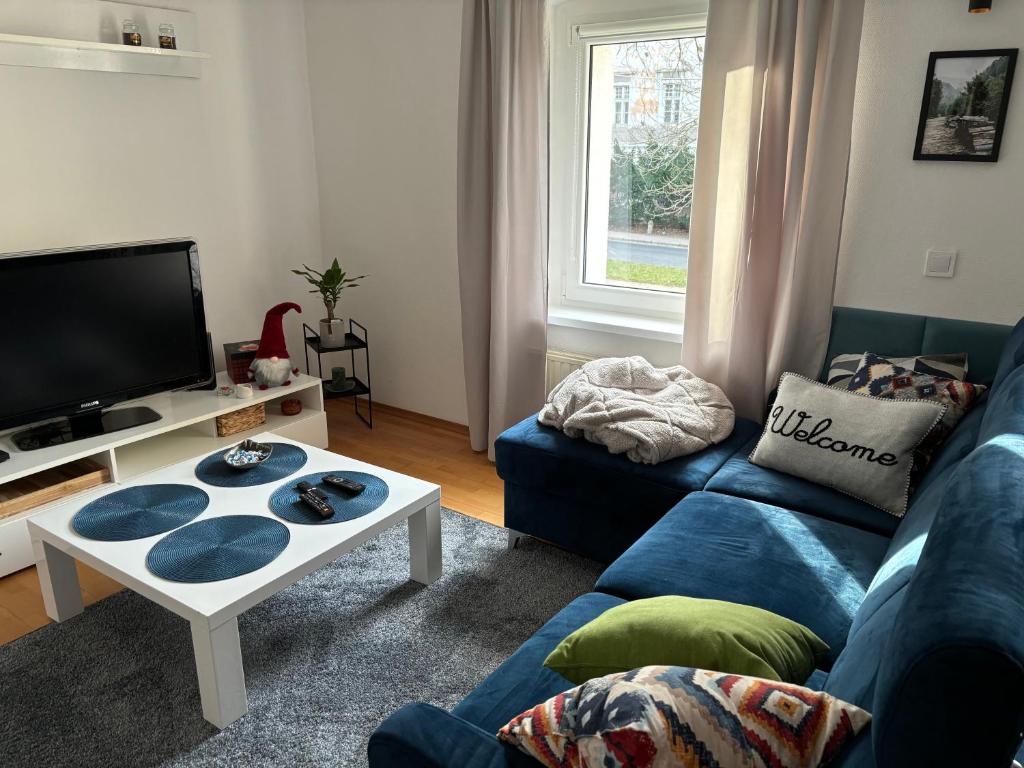 ein Wohnzimmer mit einem blauen Sofa und einem Tisch in der Unterkunft Apartament nad rzeką in Kowary