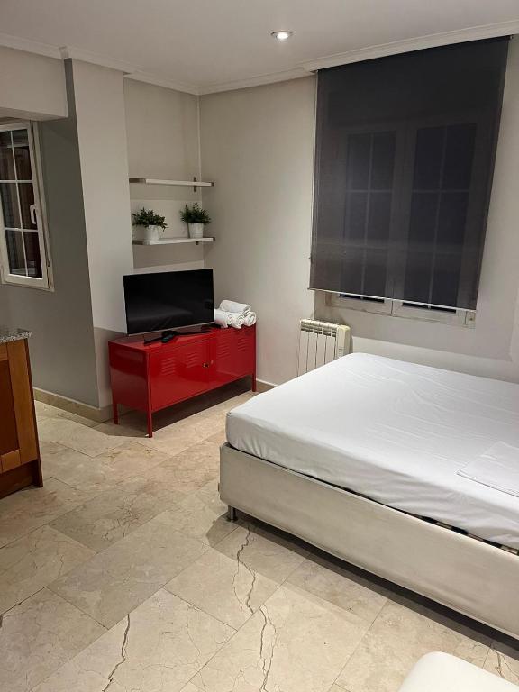 Schlafzimmer mit einem Bett und einem Flachbild-TV in der Unterkunft Exyca Malasaña in Madrid
