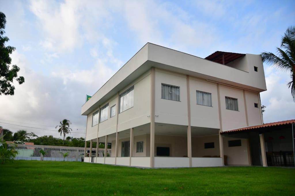 圣阿马鲁Casa das Dunas Residence até 8 pessoas (apto 3)的一座白色的大建筑,设有绿色草坪