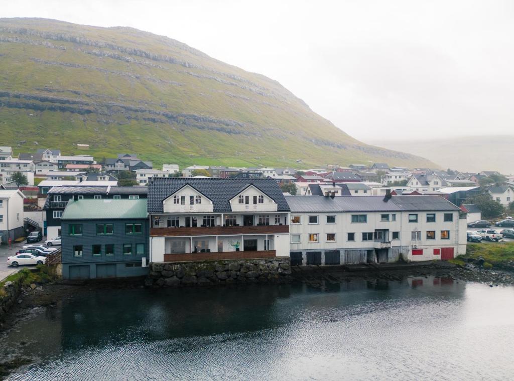 a group of buildings next to a body of water at Spacious City Center Home by the Sea in Klaksvík