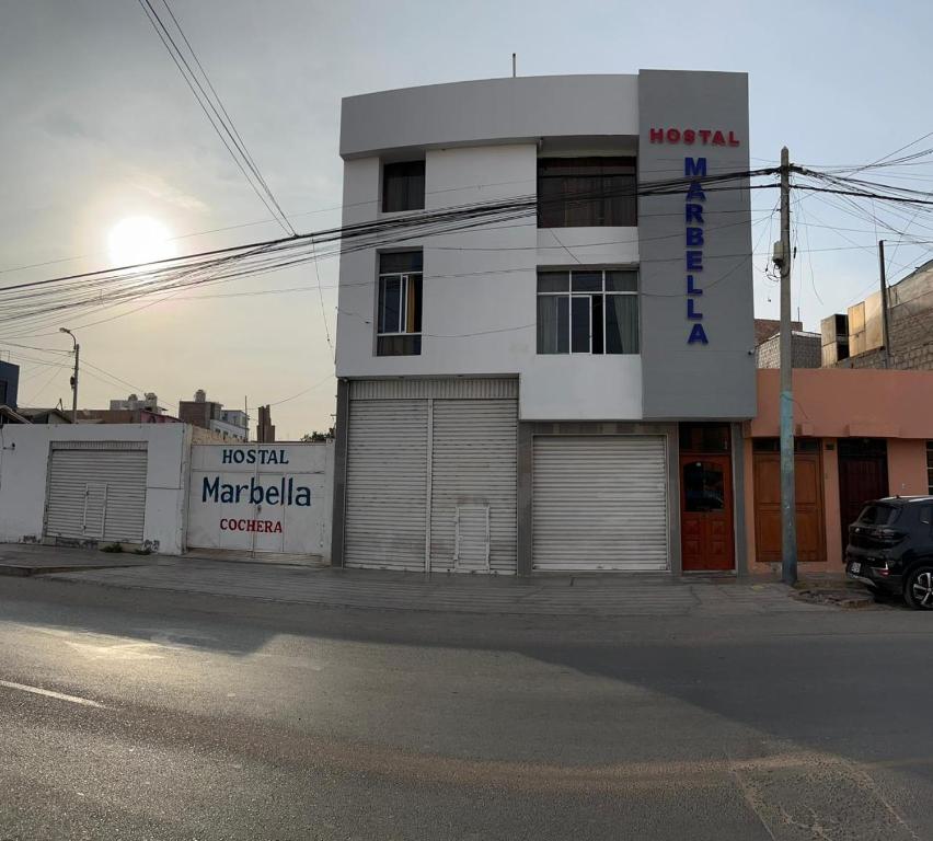 a white building on the corner of a street at Hostal Marbella in Camaná