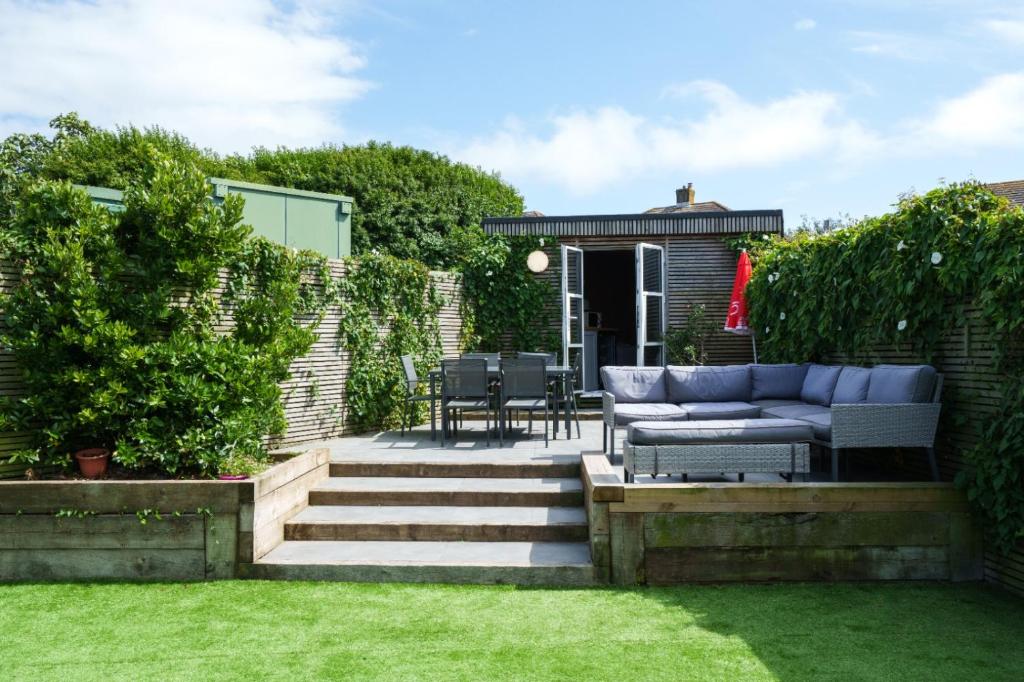 a patio with a couch and chairs on the grass at Baggies No.2 in Brighton & Hove