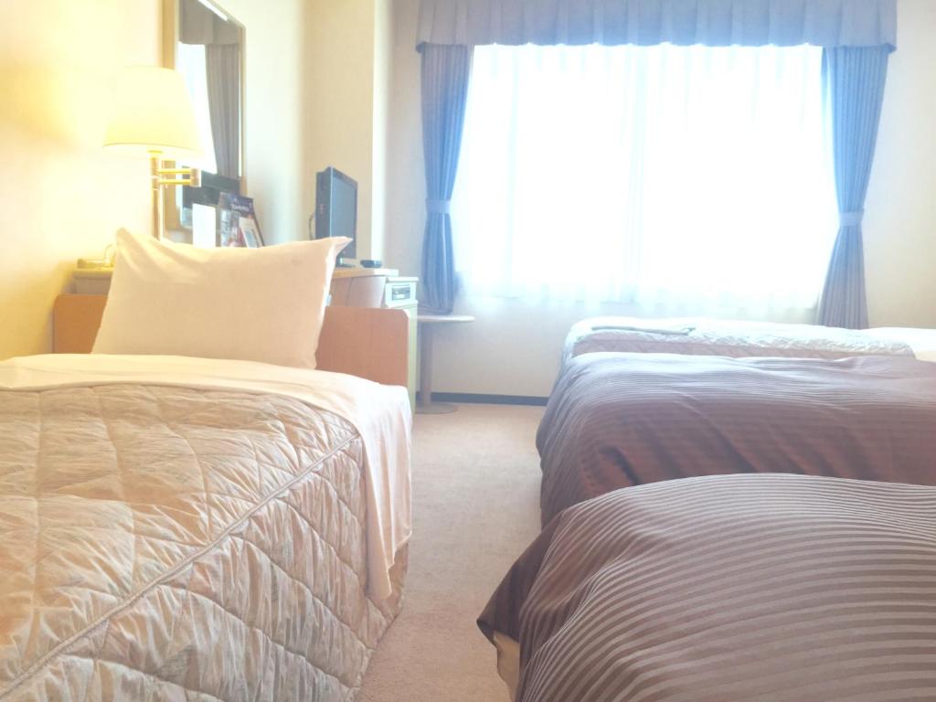 Postel nebo postele na pokoji v ubytování Hotel Green Tower Makuhari