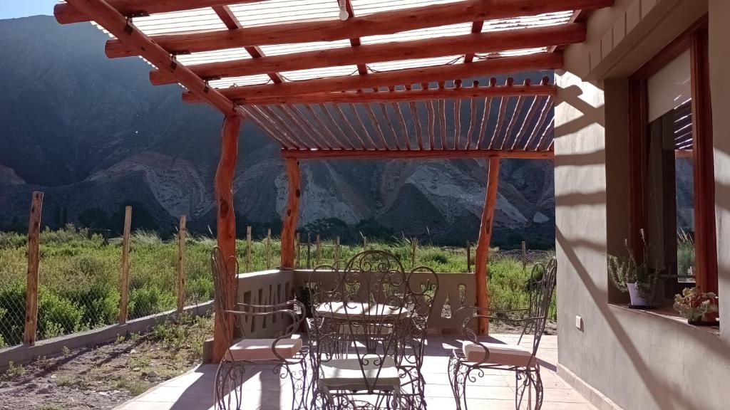 a table and chairs on a porch with a pergola at Alojamiento La Bonita de Maimará in Maimará