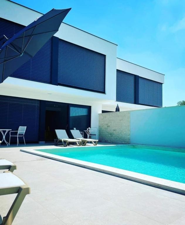 a swimming pool in front of a house at Villa Melanie in Umag