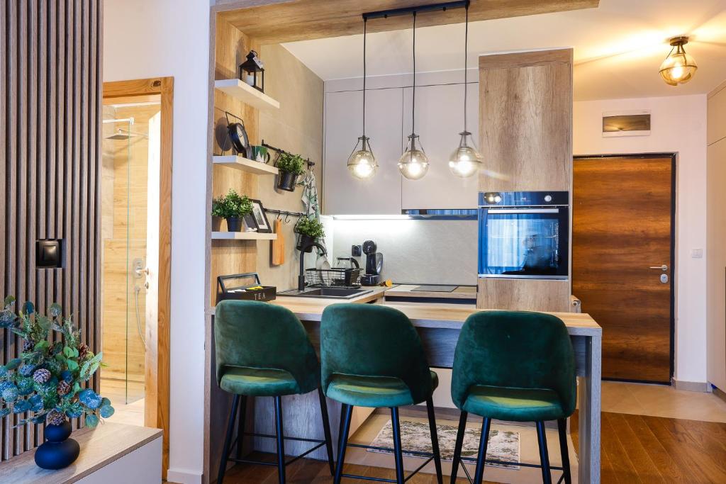 eine Küche mit grünen Stühlen und eine Kücheninsel in der Unterkunft Apartmani Aria Jahorina in Jahorina