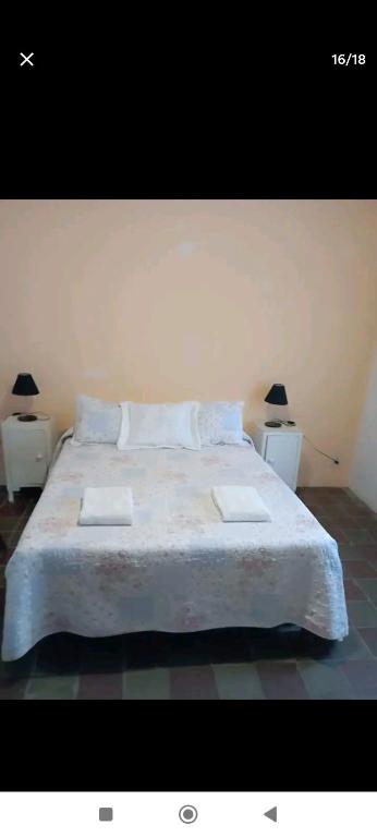 a bedroom with a large bed with two night stands at Carmelo in Carmelo