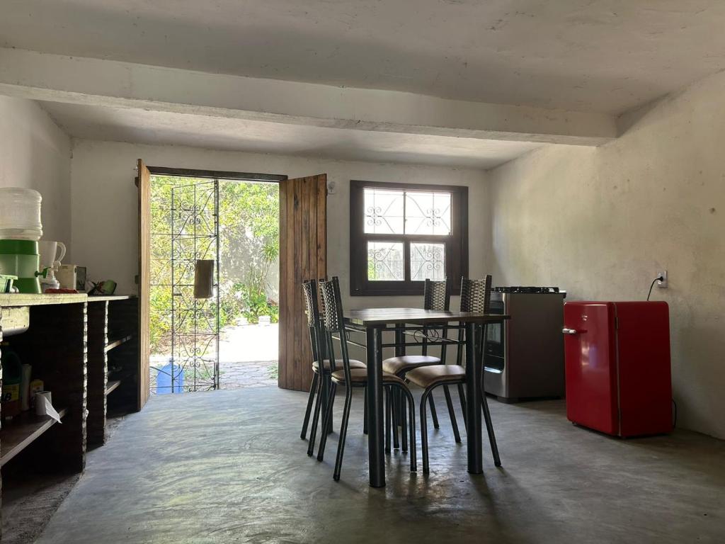 a kitchen with a table and chairs and a red refrigerator at Aconchegante Casa Rústica ao lado da Praia in Santa Cruz Cabrália