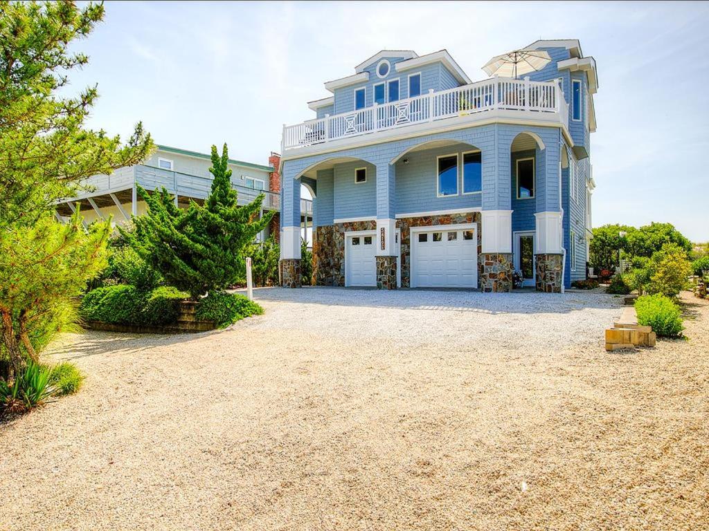 a large blue house with a large driveway at Beautifully Renovated Ocean Front Home In Harvey Cedars in Harvey Cedars