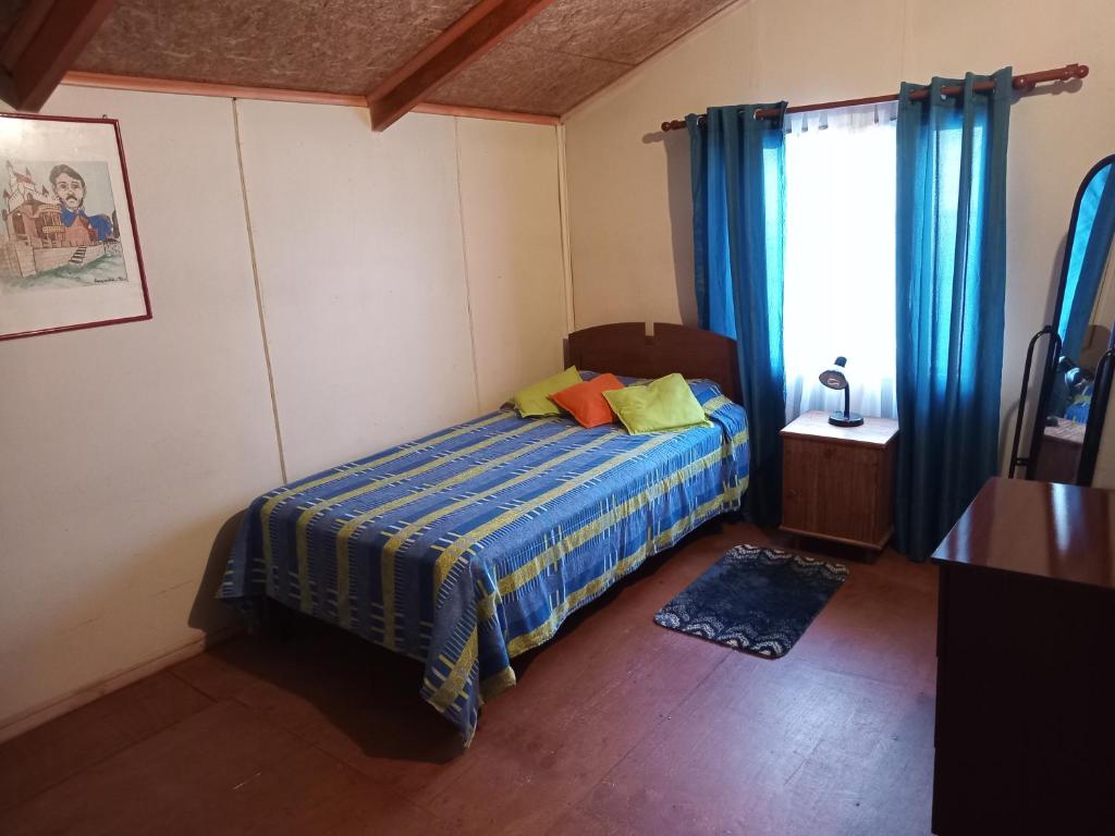niewielka sypialnia z łóżkiem i oknem w obiekcie HOSPEDAJE POR TEMPORADA VERANO COYHAIQUE w mieście Coihaique