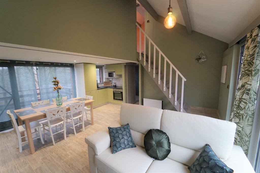- un salon avec un canapé blanc et une table dans l'établissement Chalet Kiwi, à Hastière-par-delà