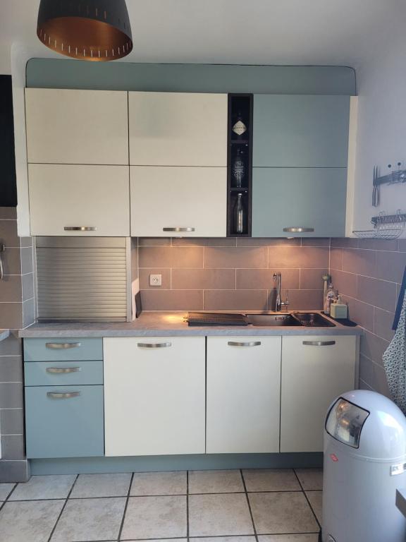 uma cozinha com armários brancos e um lavatório em Maison avec piscine, oliviers, belle vue, au calme em Trans-en-Provence