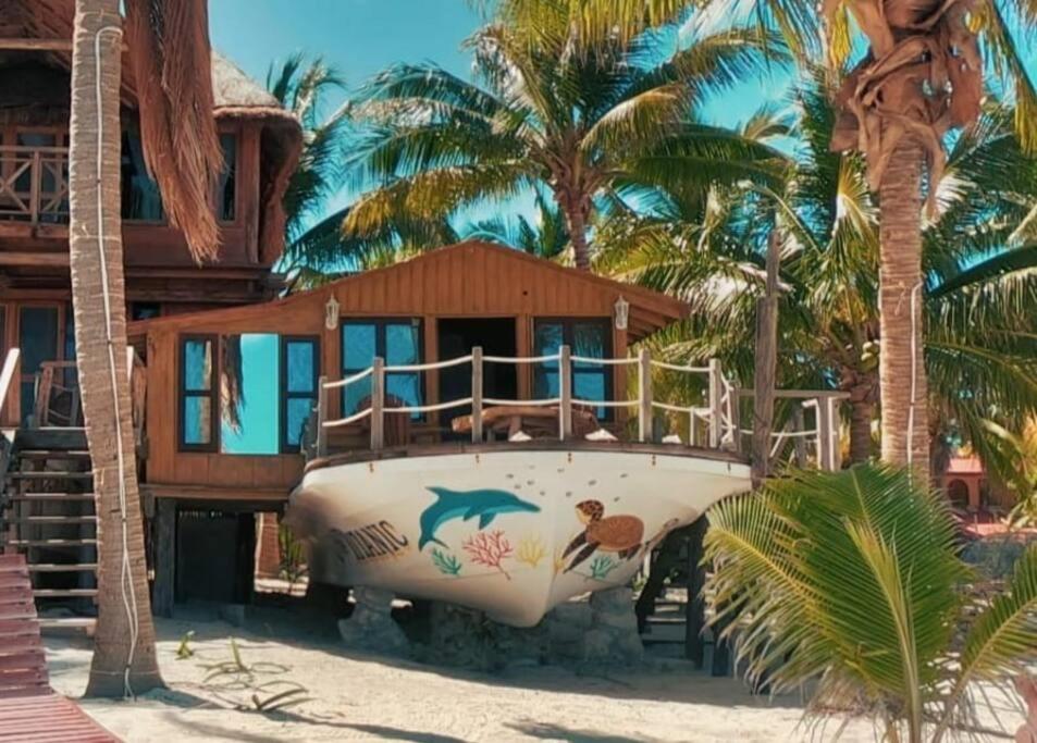 a boat on the beach with a house at Grand Titanic, Boat House in Punta Allen