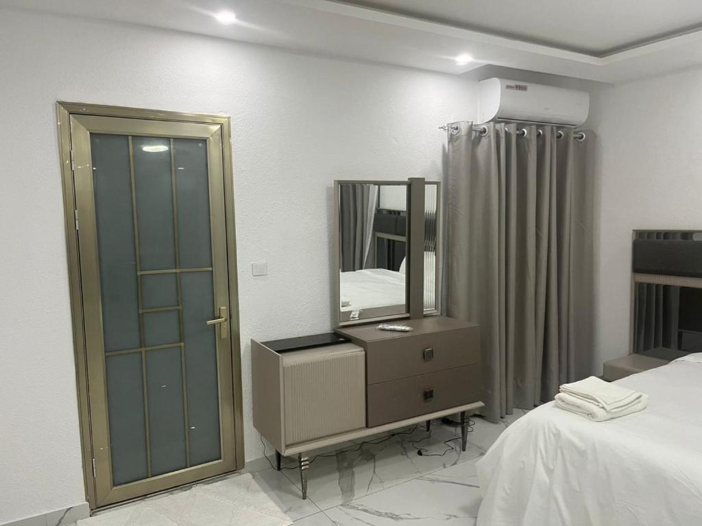 a bedroom with a mirror and a dresser and a bed at Residence Roume Abidjan Plateau in Abidjan