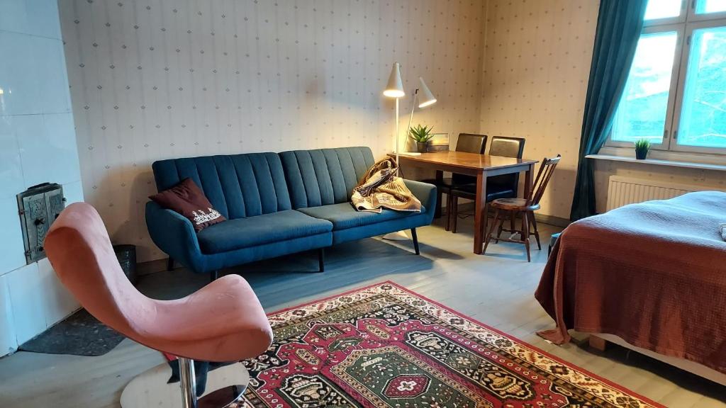 a living room with a blue couch and a table at Entisajan Helmi in Tampere