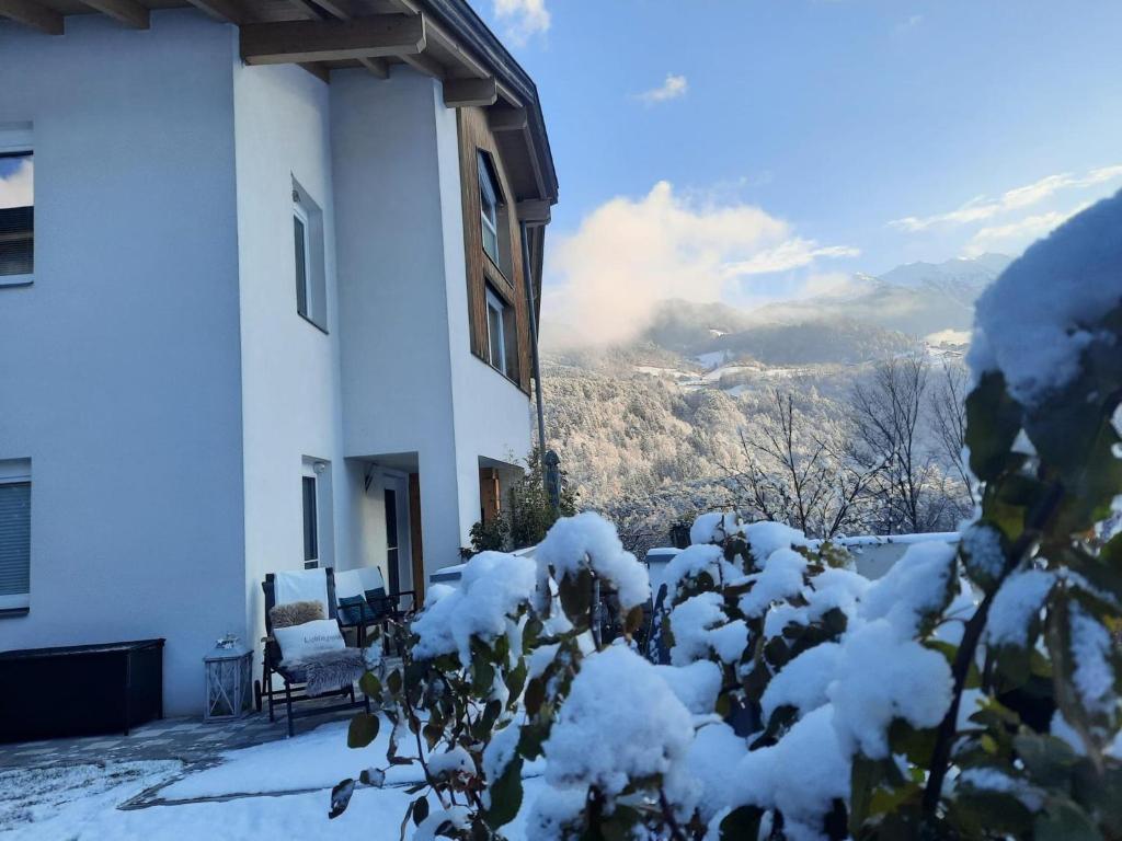 un edificio ricoperto di neve con una montagna sullo sfondo di Garden Relax Apart a Sautens