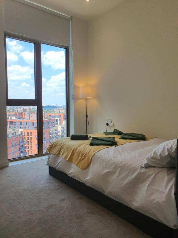 um quarto com uma cama e uma grande janela em Cozy Room with Private Bathroom in Luxurious Flat em Londres