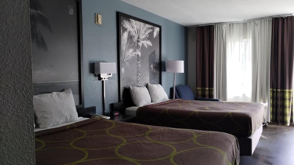 Habitación de hotel con 2 camas y ventana en Super 8 Motel by Wyndham near Fort Lauderdale Arpt, en Dania Beach