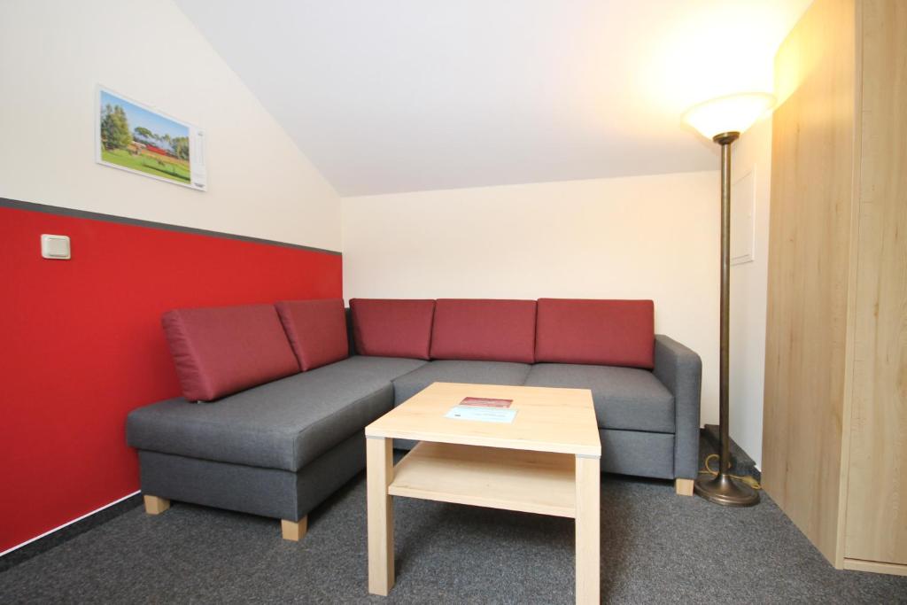 a living room with a couch and a table at Mollibahnhof - Heiligendamm Mollibahnhof Ferienwohnung 05 in Heiligendamm