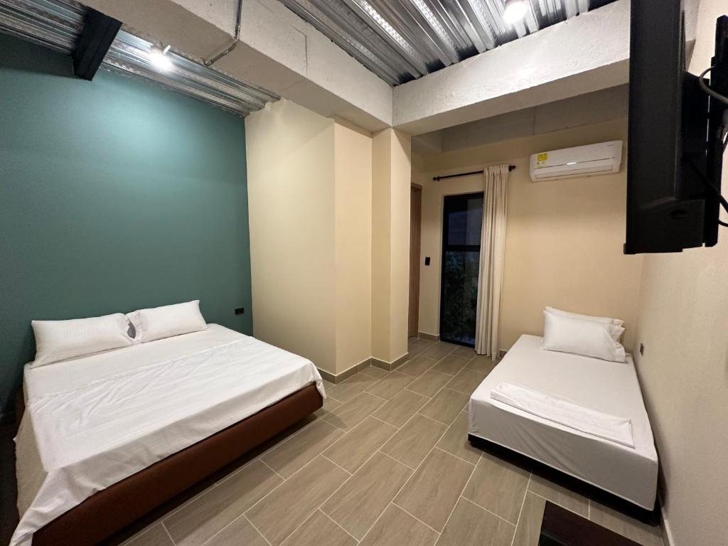 een kamer met 2 bedden en een tv. bij Awa House Hotel in Aguachica