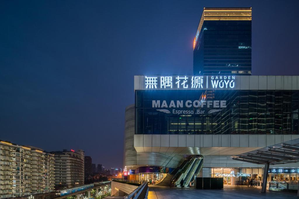 un grand bâtiment avec un panneau la nuit dans l'établissement Wuyu Hotel Chongqing Yangjiaping The Mixc, à Chongqing