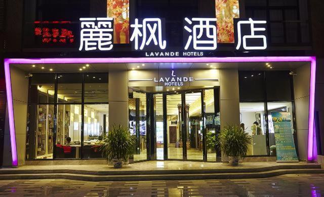 湛江市にあるLavande Hotel Zhanjiang Guomaoの紫の看板が目の前にある店