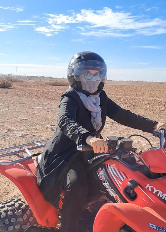 uma pessoa a conduzir uma moto vermelha no deserto em Gondotour Quad tour em São Pedro da Cova