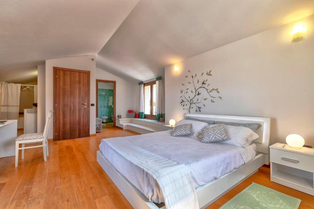 een slaapkamer met een groot bed en een badkamer bij Sardinia Guest House in Olmedo