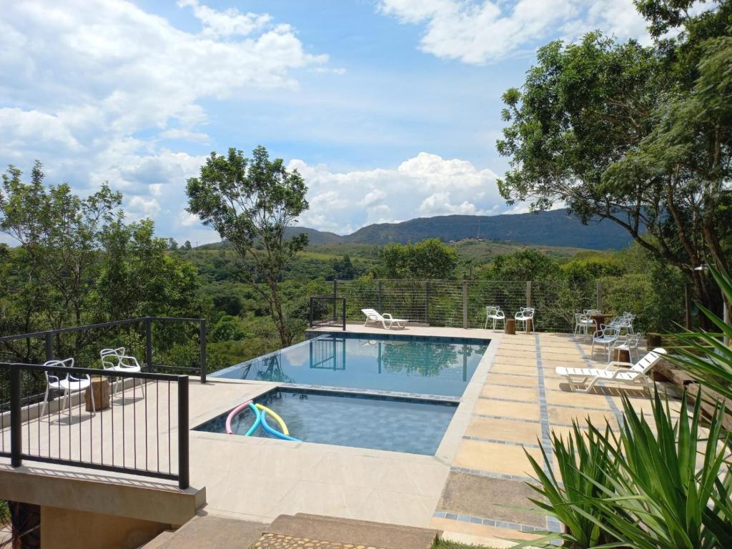 a swimming pool with mountains in the background at Pousada Cantares in Tiradentes