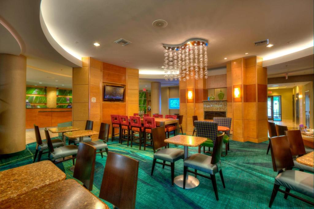 a restaurant with tables and chairs and a chandelier at SpringHill Suites by Marriott - Tampa Brandon in Tampa