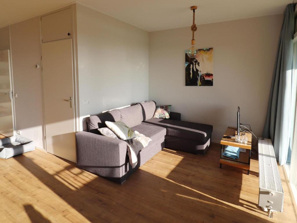 a living room with a couch and a table at Sunny apartment directly on the Heegermeer in Heeg