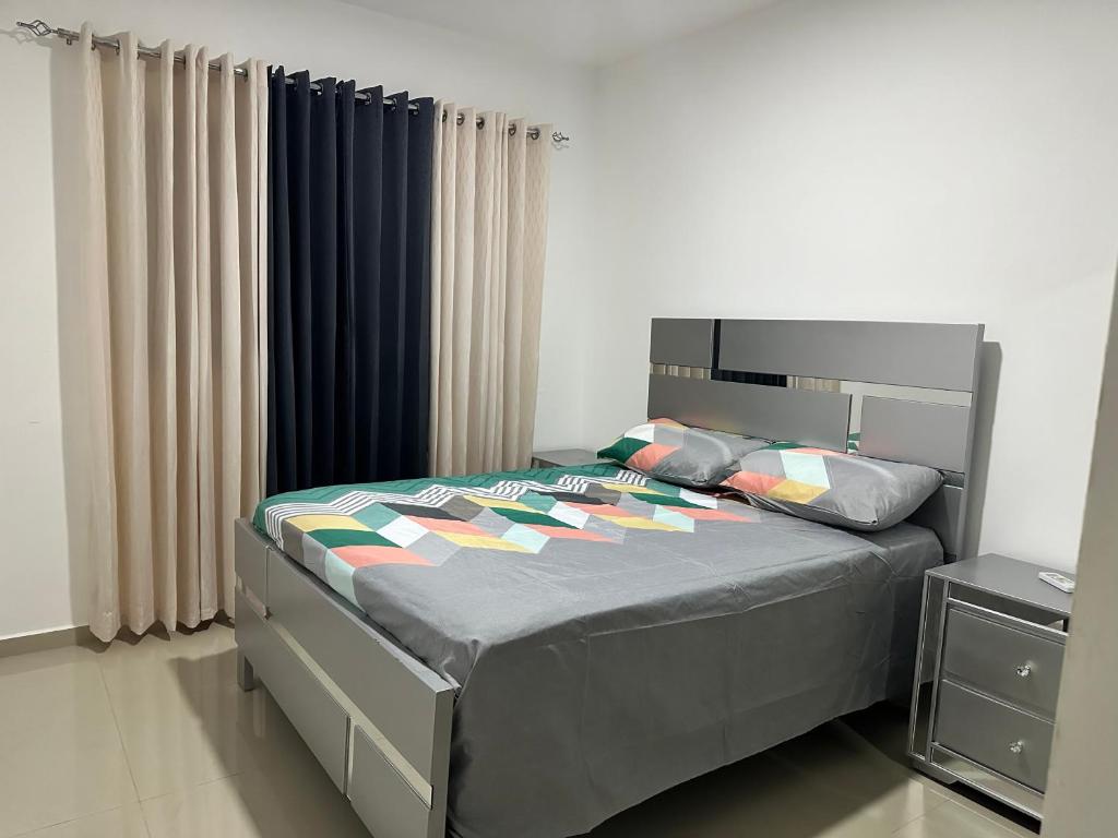 una camera con letto e piumone blu di Apartamento Amueblado en Bonao a Bonao
